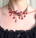 Collier fantaisie rouge/orange à pampilles et strass papillon